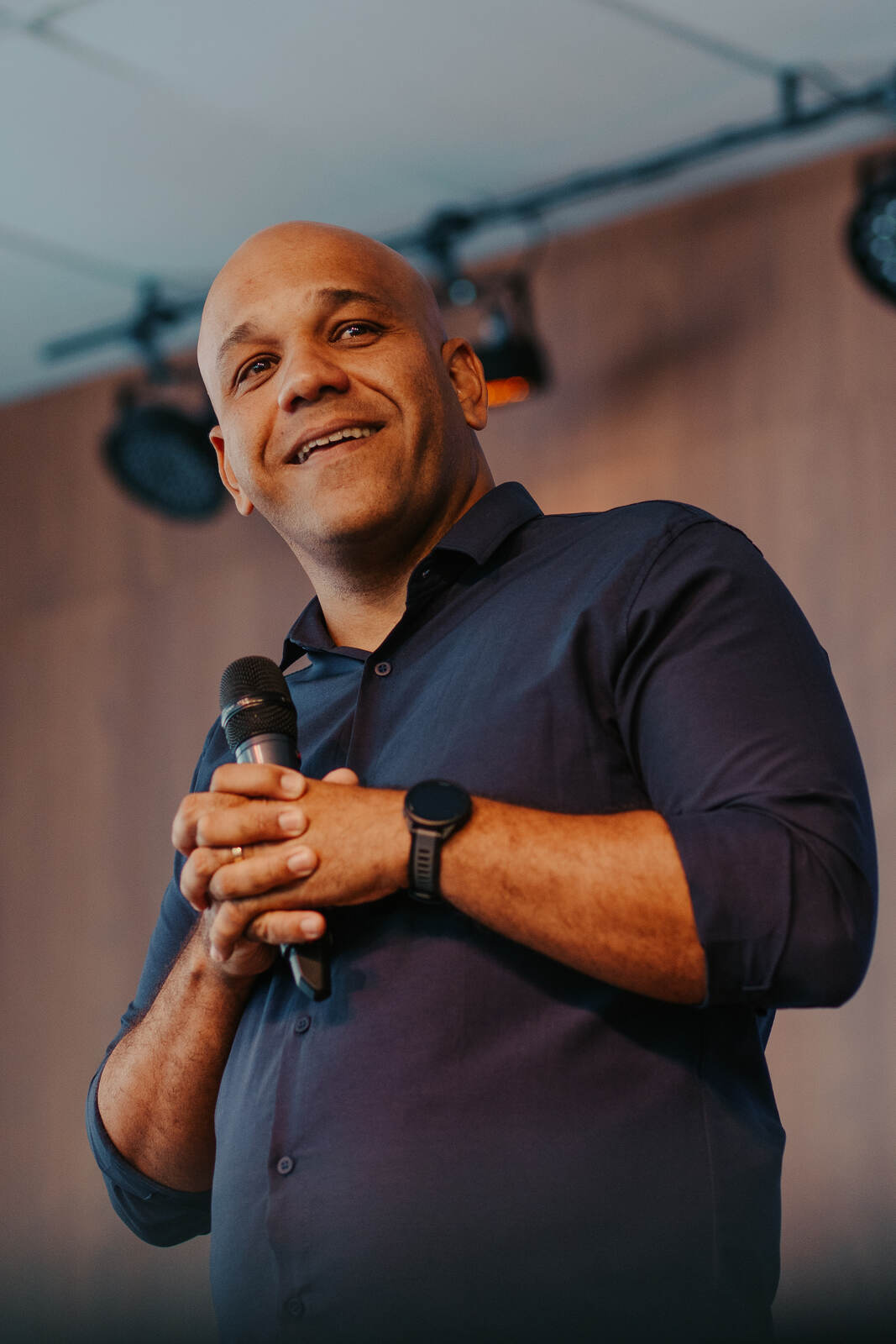 Pastor sorrindo com o microfone nas mãos