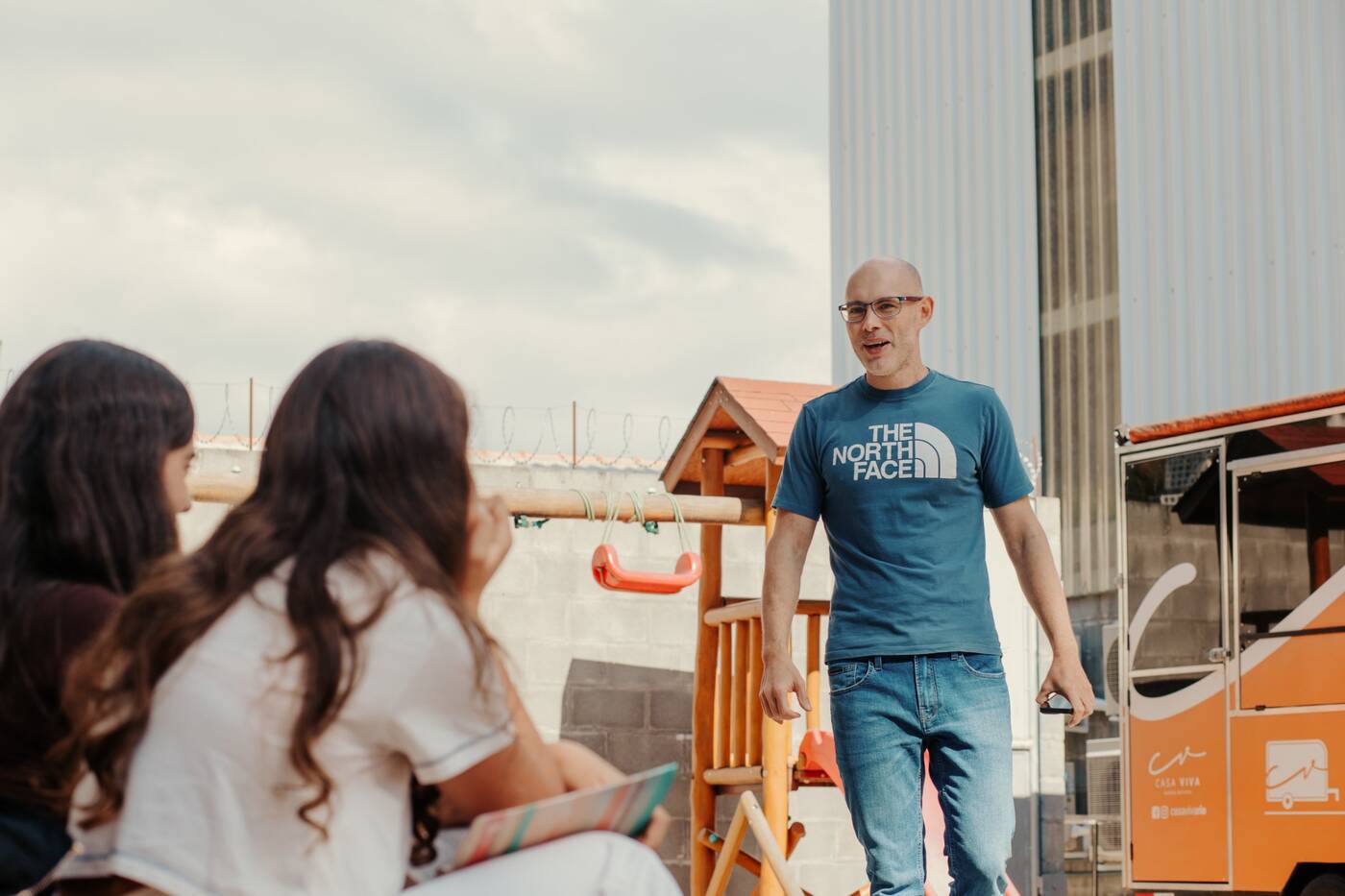 Líder conversando com adolescentes ao ar livre