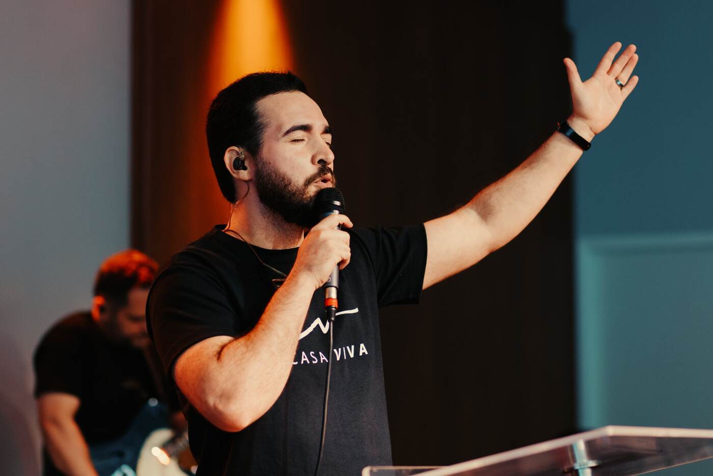 Líder de louvor cantando de braço erguido